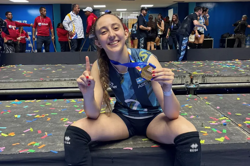 Azul Pérez Tucci sonríe con la medalla de campeona y la camiseta de Argentina, sentada sobre el escenario lleno de papelitos después de la final