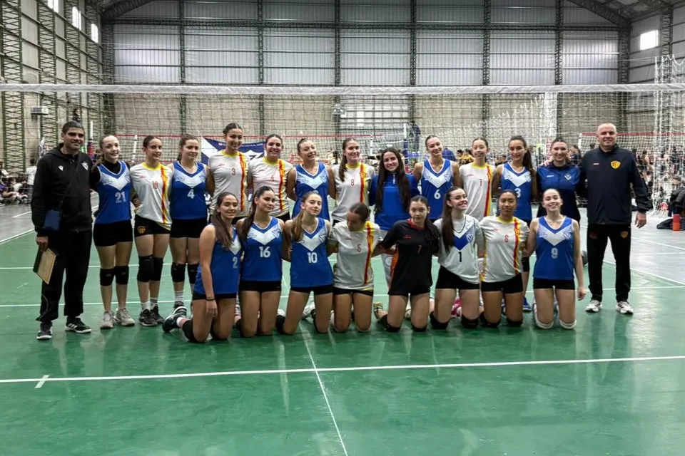Las jugadoras de la Sub 16 femenino de Vélez, de azul, posan en la cancha junto a las de su rival y a los dos cuerpos técnicos