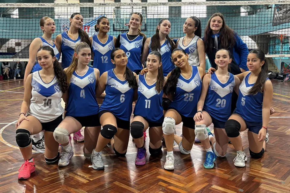 Foto del equipo VELEZ B femenino de la Sub 14 con su entrenadora, frente a la red
