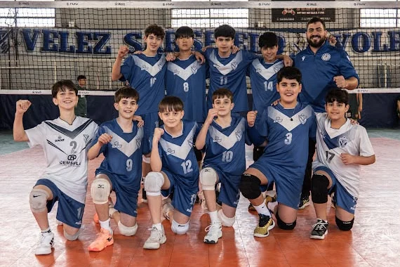 Foto del equipo VELEZ C masculino de la Sub 14 con su entrenador, frente a la red
