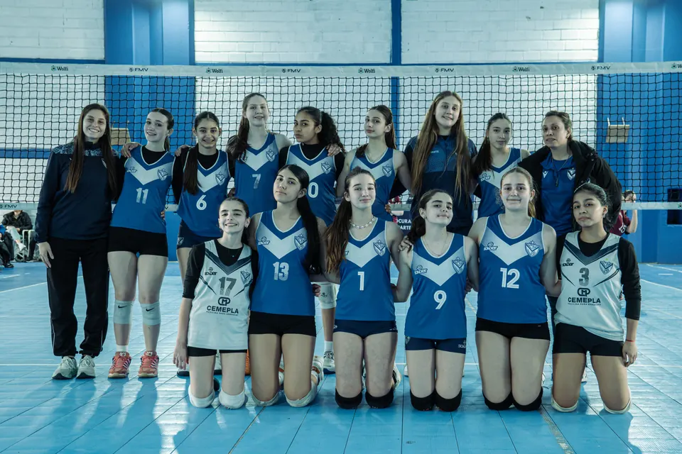 Foto del equipo VELEZ femenino de la Sub 14 con sus dos entrenadoras, frente a la red en el Anexo Alcides Márquez