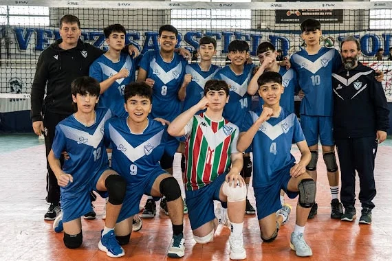 Foto del equipo VELEZ masculino de la Sub 14 con sus dos entrenadores, frente a la red